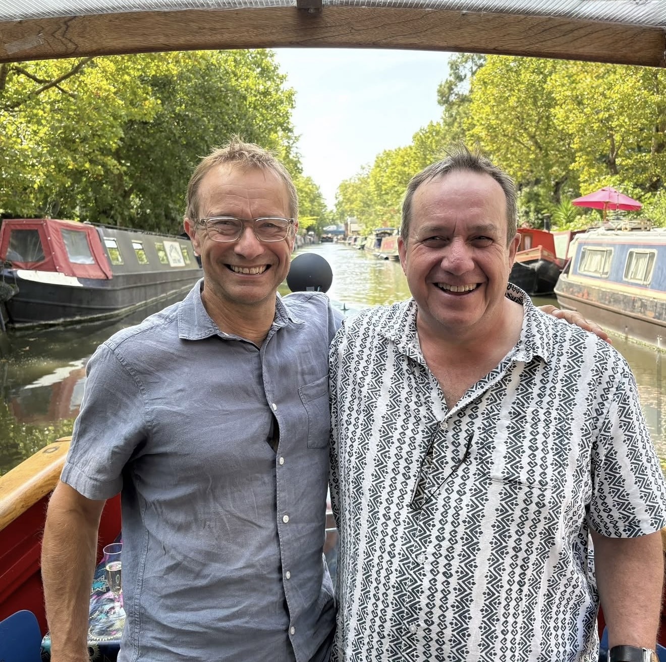Tony and Alisdair, the founders of Qtango, smiling together on a canal boat in London
